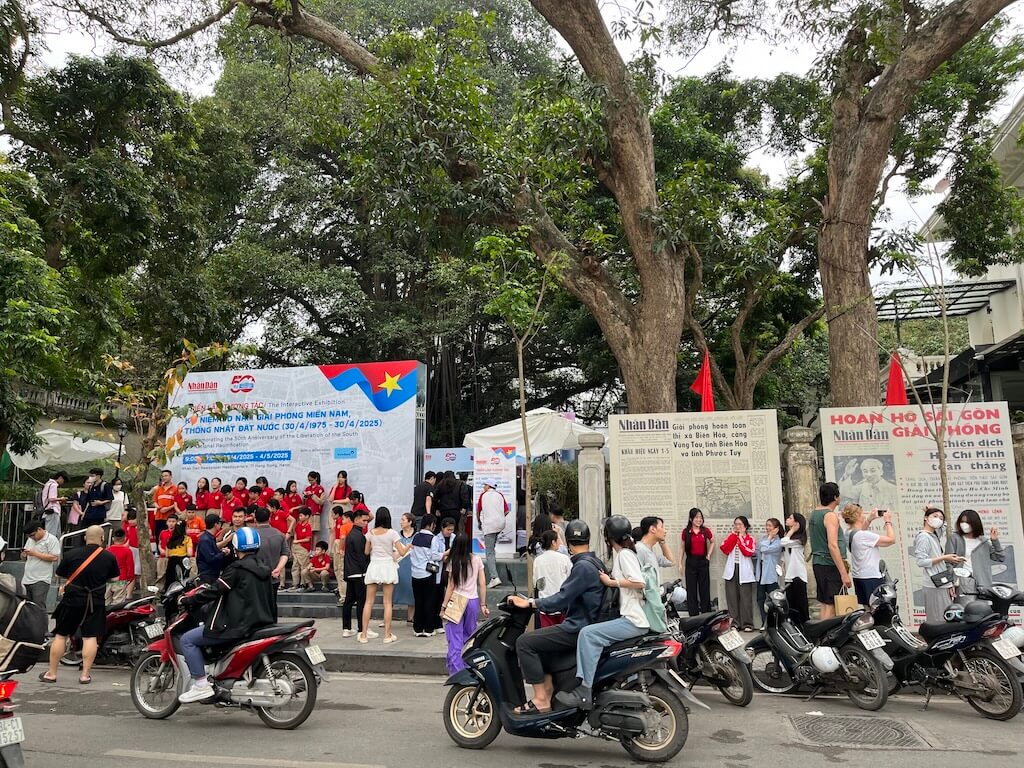 4月のハノイ、路上に集まる半袖姿の人々。強い日差しと夏の訪れを感じさせる現地の様子。