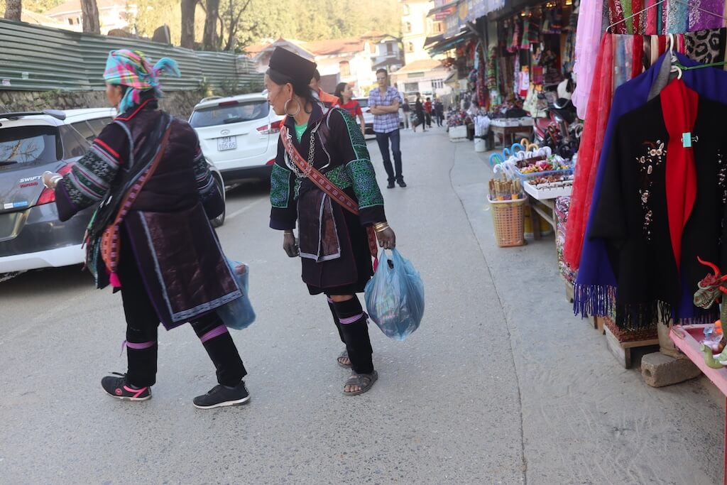ベトナム北部山岳地帯の街サパを、色鮮やかな刺繍の民族衣装で歩くモン族の女性たち。独自の文化が息づく北部の多民族社会を象徴する光景。